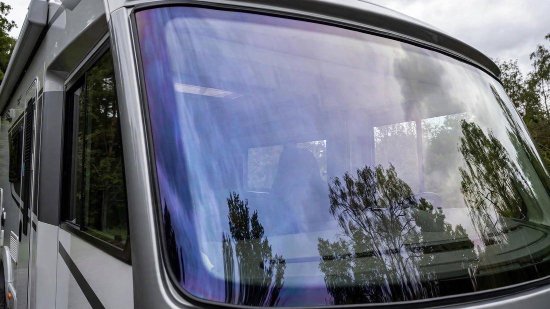 Pare-brise de camping-car vu de l'extérieur, reflet bleuté caractéristique d'un vitrage athermique métallisé